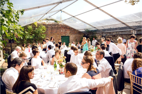 Marquee with clear roof, and guest seated for dinner Marquee hire in Sussex with clear roof and guests seated for dinner.