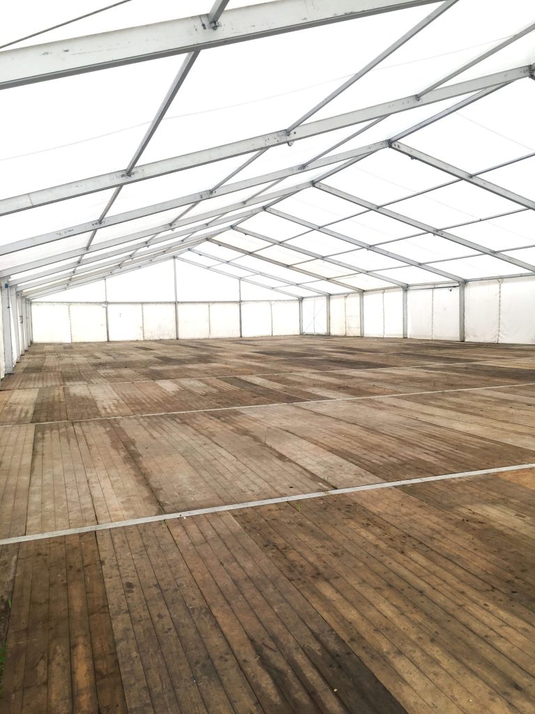 A wooden floor inside a large outdoor marquee to stabilise the ground