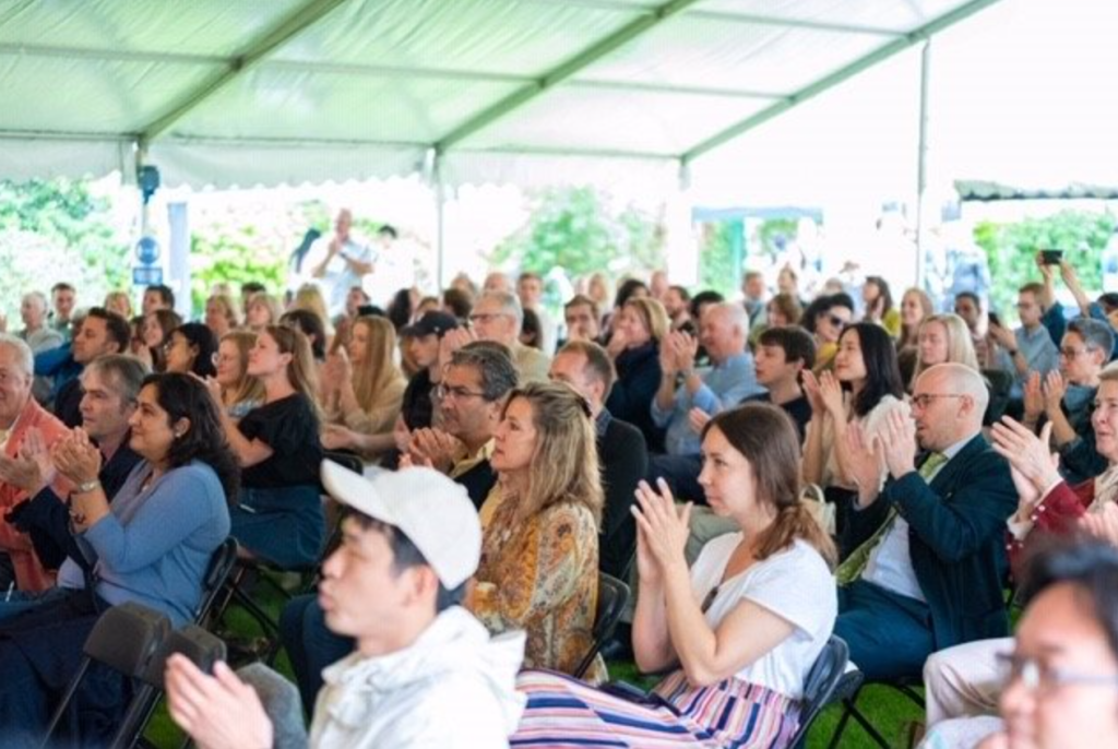 A clapping crowd sitting inside a marquee for the Marylebone Music Festival