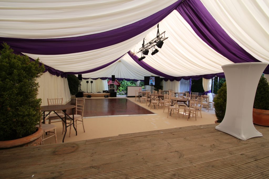 Marquee hire Surrey , an internal view with purple roof overlays and swag and champagne carpet